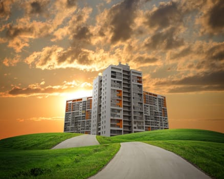 Buildings, green hills and road against dramatic sky with clouds. Architectural concept