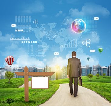 Businessman walks on road. Rear view. Buildings, grass field and sky with Earht and other virtual elements. Elements of this image furnished by NASA