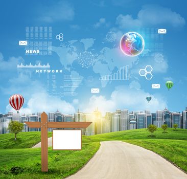 Wooden signboard standing on green grass near road. Buildings and Earth with virtual elements as backdrop. Business concept. Elements of this image furnished by NASA