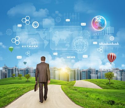 Businessman walks on road. Rear view. Buildings, grass field and sky with Earht and other virtual elements. Elements of this image furnished by NASA