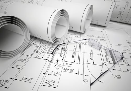 Scrolls of engineering drawings and glasses on drawing. Industrial concept