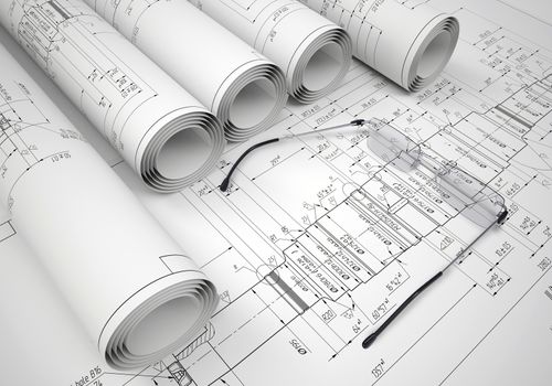 Scrolls of engineering drawings and glasses on drawing. Industrial concept