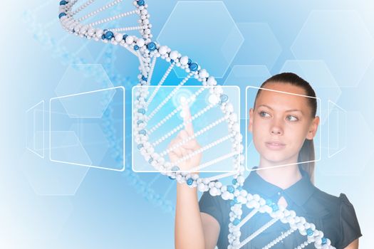 Beautiful businesswoman in dress presses finger on model of DNA. Scientific and medical concept