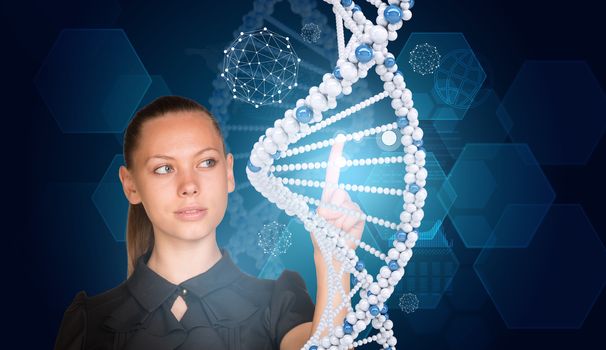 Beautiful businesswoman in dress presses finger on model of DNA. Scientific and medical concept