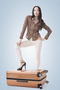 Modern Asian woman stand on a luggage.