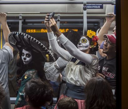 TUCSON, AZ/USA - NOVEMBER 09: Unidentified woman takes a selfie on the Tucson Trolley the All Souls Procession on November 09, 2014 in Tucson, AZ, USA.