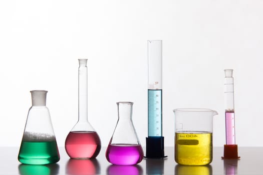 Glass in a chemical laboratory filled with colored liquid during the reaction - studio shoot