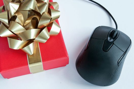 Computer mouse and christmas gift box with gold ribbon bow 