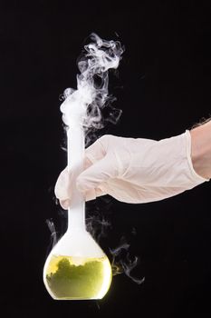 Chemical reaction in volumetric flask glass kept in the hands of scientist - studio shoot