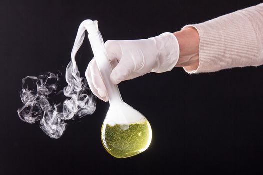 Chemical reaction in volumetric flask glass kept in the hands of scientist - studio shoot