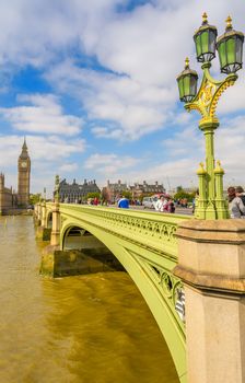 LONDON - SEPTEMBER 29, 2013: Tourists walk on Westminster Bridge on a beautiful day. The city is visited by more than 30 million people every year.