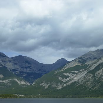 Large rocky mountains with trees and lake