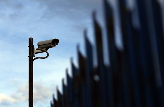 silhouette of a security camera and fence