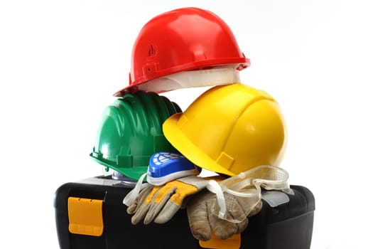 Some color protective helmets and toolbox on white 