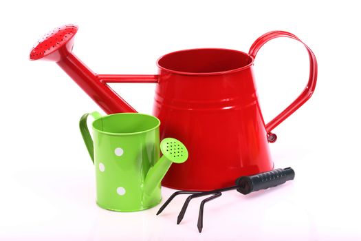 red and green watering cans on white  background