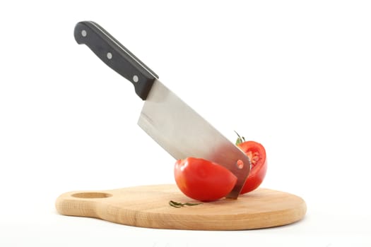 cleaver bisects tomato on cutting board