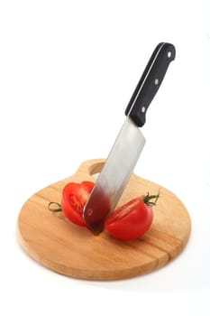 cleaver bisects tomato on cutting board