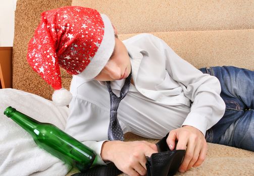 Teenager in Santa Hat Checking Empty Wallet after Party on the Sofa