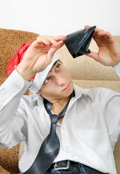 Teenager in Santa Hat Checking Empty Wallet on the Sofa at the Home