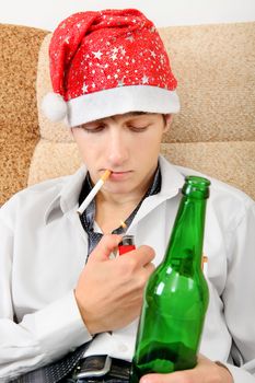 Teenager in Santa Hat with Bottle of the Beer smoking Cigarette