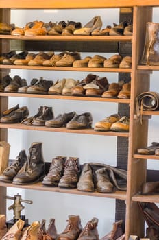Shelf with old shoes in a antique cobbler shoe repair shop
