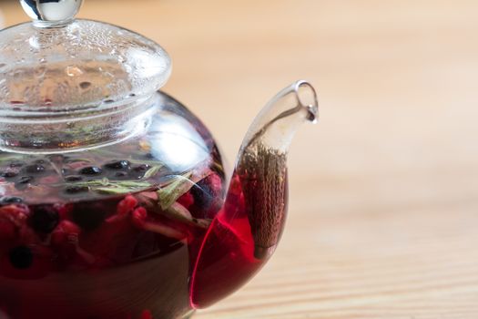 tea from the berries in a glass pot
