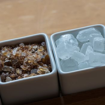 white and brown sugar on wooden table. Selective focus