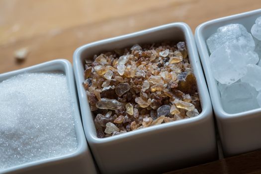 white and brown sugar on wooden table. Selective focus