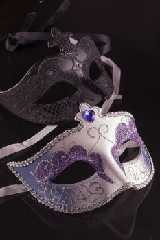Venetian artisanal masks over black reflecting background