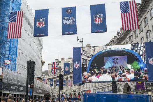 LONDON, UK - SEPTEMBER 27: American flag and NFL banners hanging above screen on Regent street. September 27, 2014 in London. Regent street was closed to traffic to host NFL related games and events.