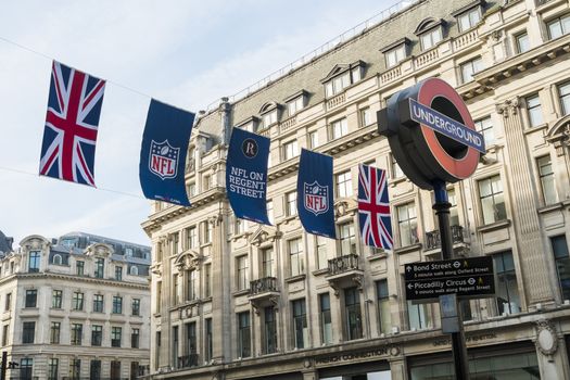 LONDON, UK - SEPTEMBER 27: Union Jack and NFL banners with London Underground sign post. September 27, 2014 in London. Regent street was closed to traffic to host NFL related games and events.