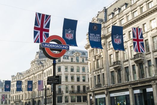 LONDON, UK - SEPTEMBER 27: Union Jack and NFL banners with London Underground sign post. September 27, 2014 in London. Regent street was closed to traffic to host NFL related games and events.