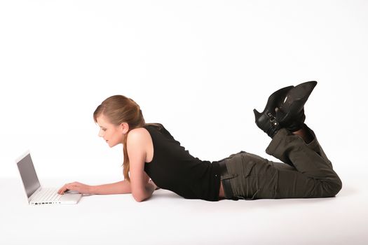 Young woman lying on the floor in front of a laptop.