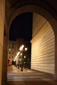 row of illuminated lampposts by night
