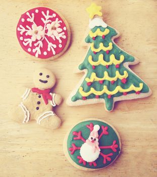Decorated christmas gingerbreads on wooden background with retro filter effect