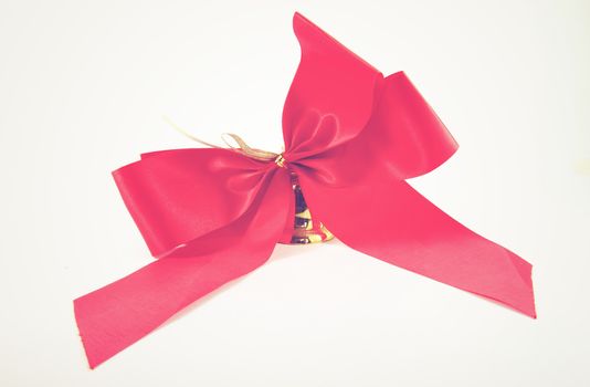 Red satin ribbon and golden bell with retro filter effect