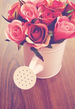 Roses in watering can for decoration with retro filter effect