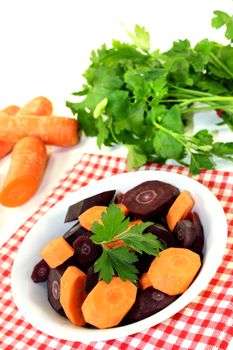 colorful carrots with parsley on a light background