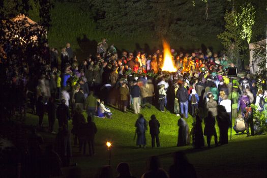 People celebrate summer solstice night around a bonfire in Latvian village. Midsumer or John's eve celebration around a bonfire is reminiscent of Midsummer's pagan rituals and very popular in Latvia.