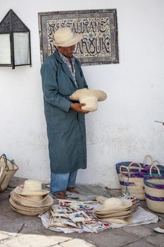 SIDI BOU SAID, TUNISIA, JUNE 19, 2012: Elder street vendor selling handmade Tunisian souvenirs from Africa.
