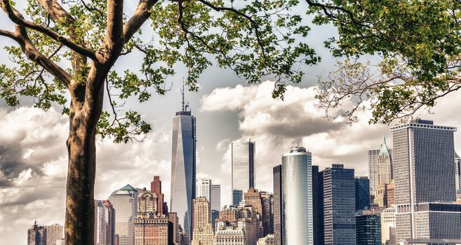 Beautiful skyline of Lower Manhattan framed by Governors Island trees in summer - New York City.
