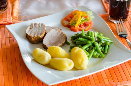 Fresh Schwenebraten with potatoes, green beans and salad.