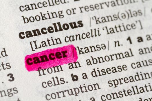 Cancer highlighted in dictionary with pen closeup