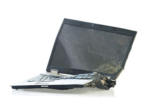 Laptop computer destroyed beyond repair in a car accident. Isolated on white background