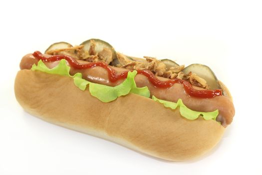 a hot dog with pickle and salad against white background