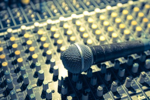 microphone and soundboard under stage lighting