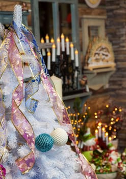 the white New Year tree decorated with tapes and toys in shop