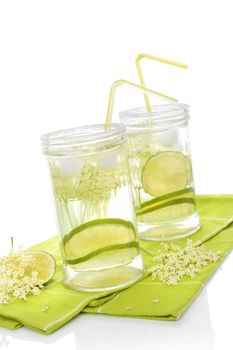Elderberry lemonade. Two glasses with elderberry lemonade with ice and lime slices isolated on white background. 