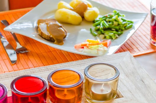 Roast pork and potatoes with salad and table decorations