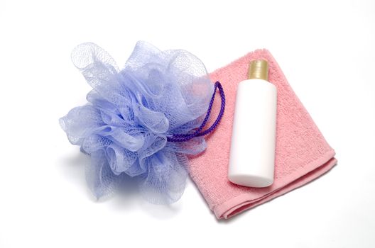 purple bath puff liquid soap and pink towel on a white background